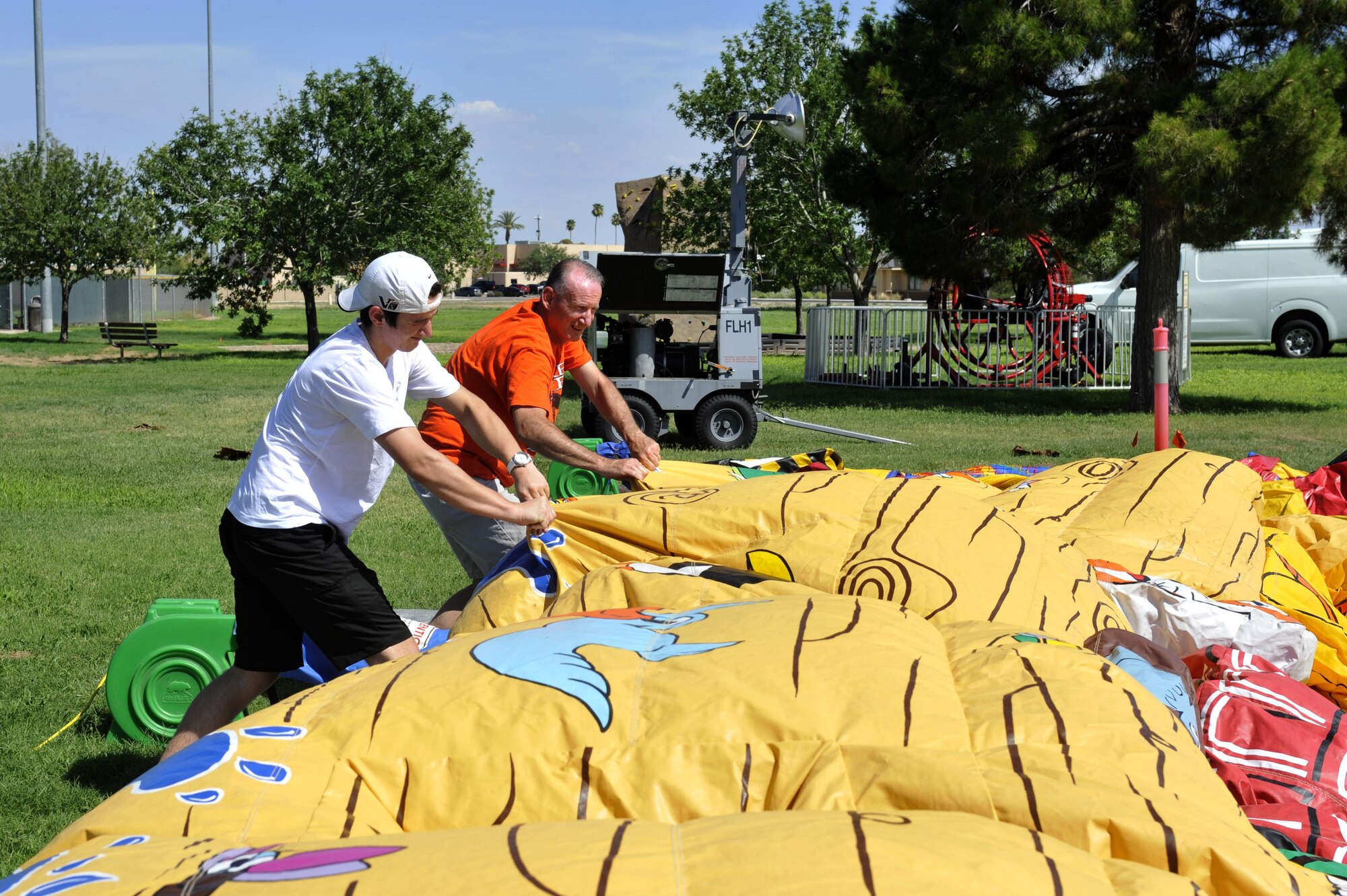 Chaplain (Maj.) David Barns and his son Jeff fill up a bounce house for the Back-to-School Bash July 26, 2017 at Luke Air Force Base, Ariz. The event is held to help families with the annual school supply costs. 