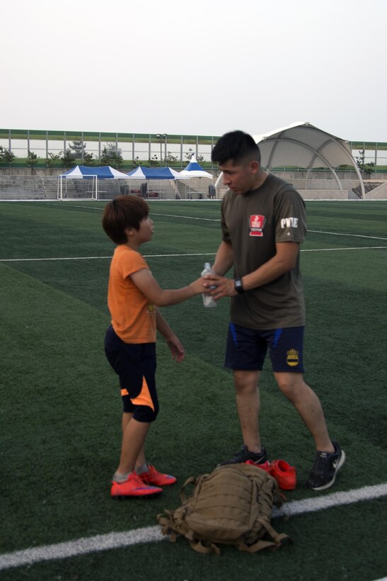 Lance Cpl. Jose Casias shares his water with one of his players July 20 in Pohang, Republic of Korea. Casias volunteers his weeknights to coach a local youth soccer team. He also teaches English classes at different grade schools and kindergartens, as well as participating in clean ups throughout the community near Camp Mujuk. Casias, an Atlanta, Georgia, native is a bulk fuel specialist with Camp Mujuk Headquarters Logistics, Marine Corps Installations Pacific. (U.S. Marine Corps photo by Sgt. Jessica Collins)