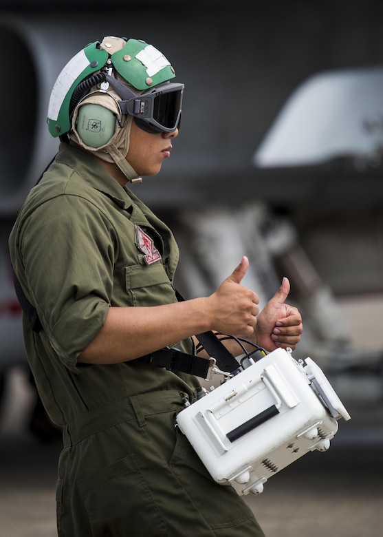 U.S. Marine Corps Lance Cpl. Alex Velasquez, a communications and navigation technician with Marine Fighter Attack Squadron (VMFA) 232, gives the good-to-go to F/A-18C Hornet pilots preparing to take off at Japan Air Self-Defense Force (JASDF) Hyakuri Air Base, Japan, July 10, 2017. VMFA-232 has been conducting exercises with the JASDF as part of the Aviation Training Relocation program, which is designed to increase operational readiness and interoperability between U.S. and Japanese forces. It reduces local noise impacts by dispersing unilateral jet-fighter training of U.S. forces in Japan. (U.S. Marine Corps photo by Lance Cpl. Mason Roy)