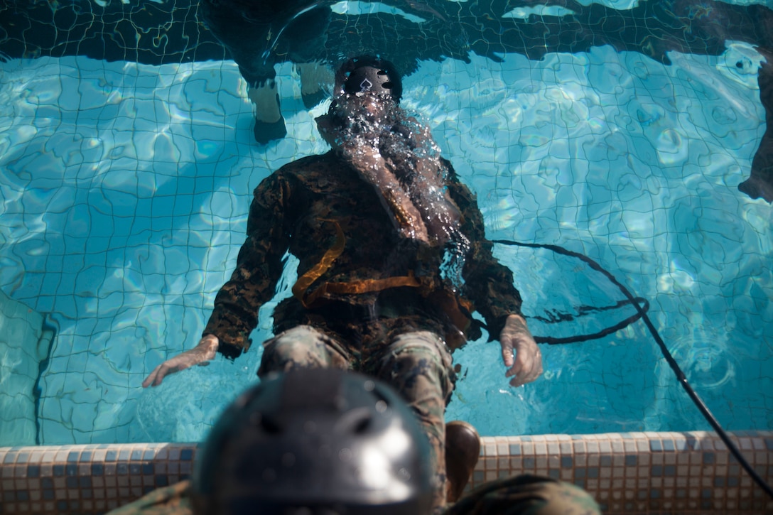 Lance Cpl. Justin Collins, a grenadier with 3rd Marine Regiment, 3rd Marine Division, practices using an Emergency Breathing System during Shallow Water Egress Training, Marine Corps Base Hawaii, July 21, 2017. In the event of an Amphibious Assault Vehicle sinking, Submerged Vehicle Egress Training and Underwater Egress Training are vital training programs that prepares Marines and Sailors on safely escaping the vehicle. (U.S. Marine Corps photo by Lance Cpl. Matthew Kirk)