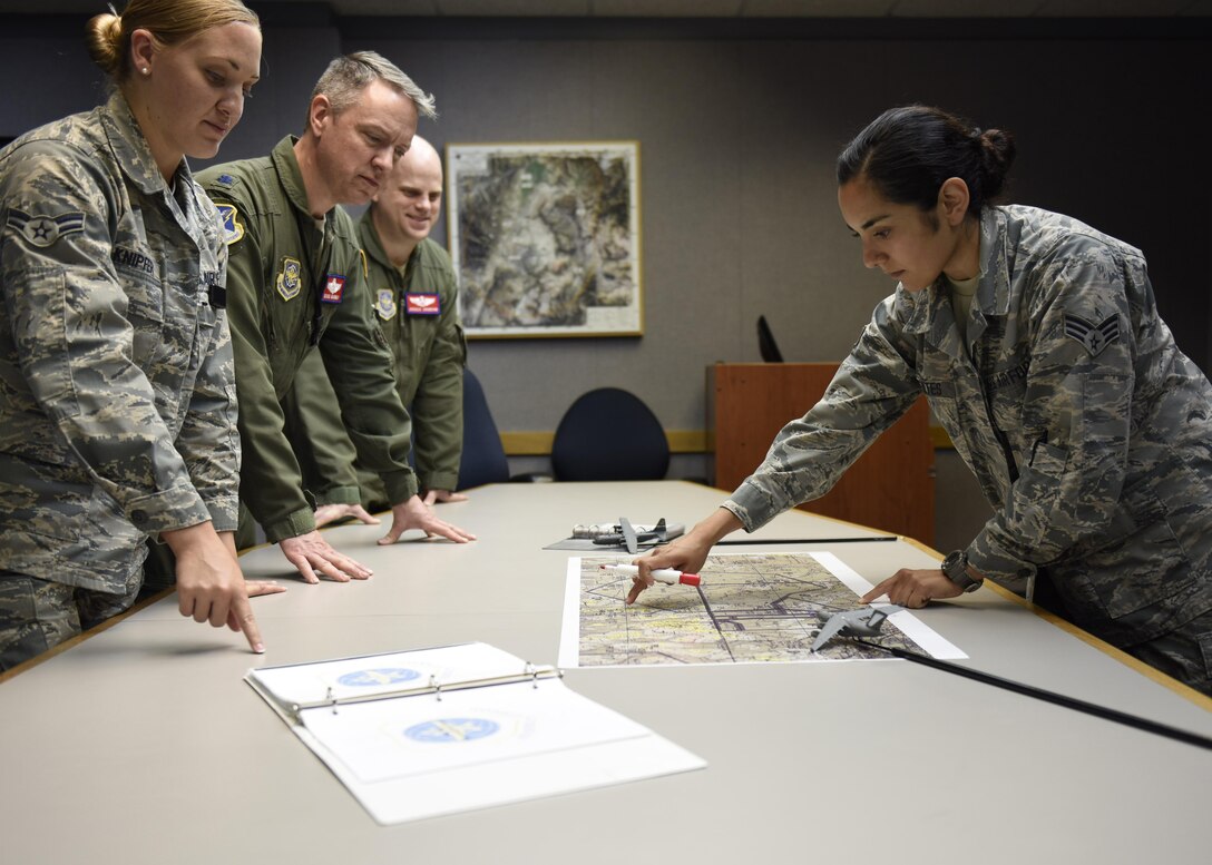 Senior Airman Brittany Fuentes, a collection requirements manager at Air Mobility Command, briefs information regarding a mobility mission to other anylysts July 18, 2017. (U.S. Air Force photo by Staff Sgt. Stephenie Wade)