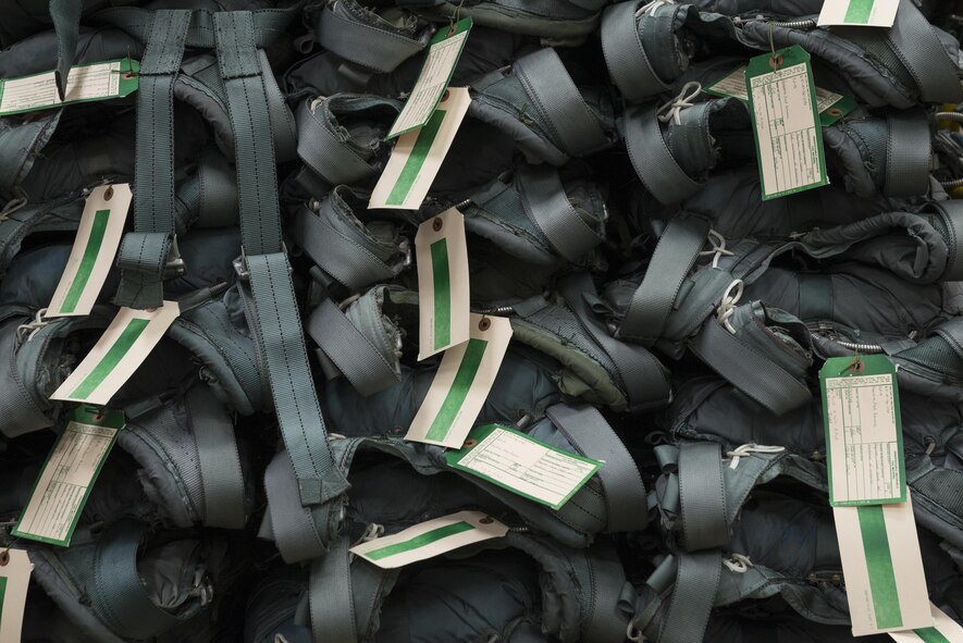 Parachutes are stacked up on a table waiting for inspection by Airmen from the 374th Operations Support Squadron Aircrew Flight Equipment, July 20, 2017 at Yokota Air Base, Japan. AFE regularly inspects, maintains, and assembles all life-support and survival equipment used by aircrew and passengers to ensure everything is ready for use. (U.S. Air Force photo by Airman 1st Class Juan Torres)

