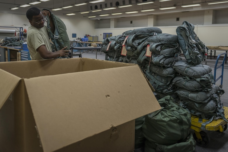 Tech. Sgt. Johnnie Sims, 403rd Operations Support Squadron Aircrew Flight Equipment technician, at Keesler Air Force Base, Mississippi, handles equipment during a 374 OSS manning assist, July 20, 2017, at Yokota Air Base, Japan. Sims assists 374 OSS with Yokota’s transition from C-130H Hercules to C-130J Super Hercules. (U.S. Air Force photo by Airman 1st Class Juan Torres)