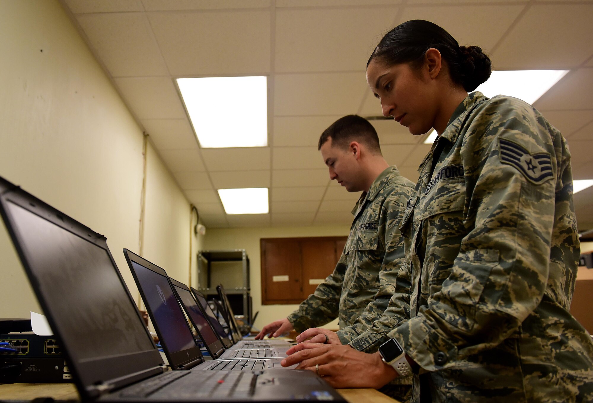 Airman 1st Class Joshua Burton and Staff Sgt. Jennifer Collins, both 4th Communications Squadron client services technicians, prepare new Windows 10 laptops for use, July 12, 2017, at Seymour Johnson Air Force Base, North Carolina. In addition to their usual workload of 40-60 trouble tickets annually, client service technicians work on 100 new computers each week. (U.S. Air Force photo by Airman 1st Class Kenneth Boyton)