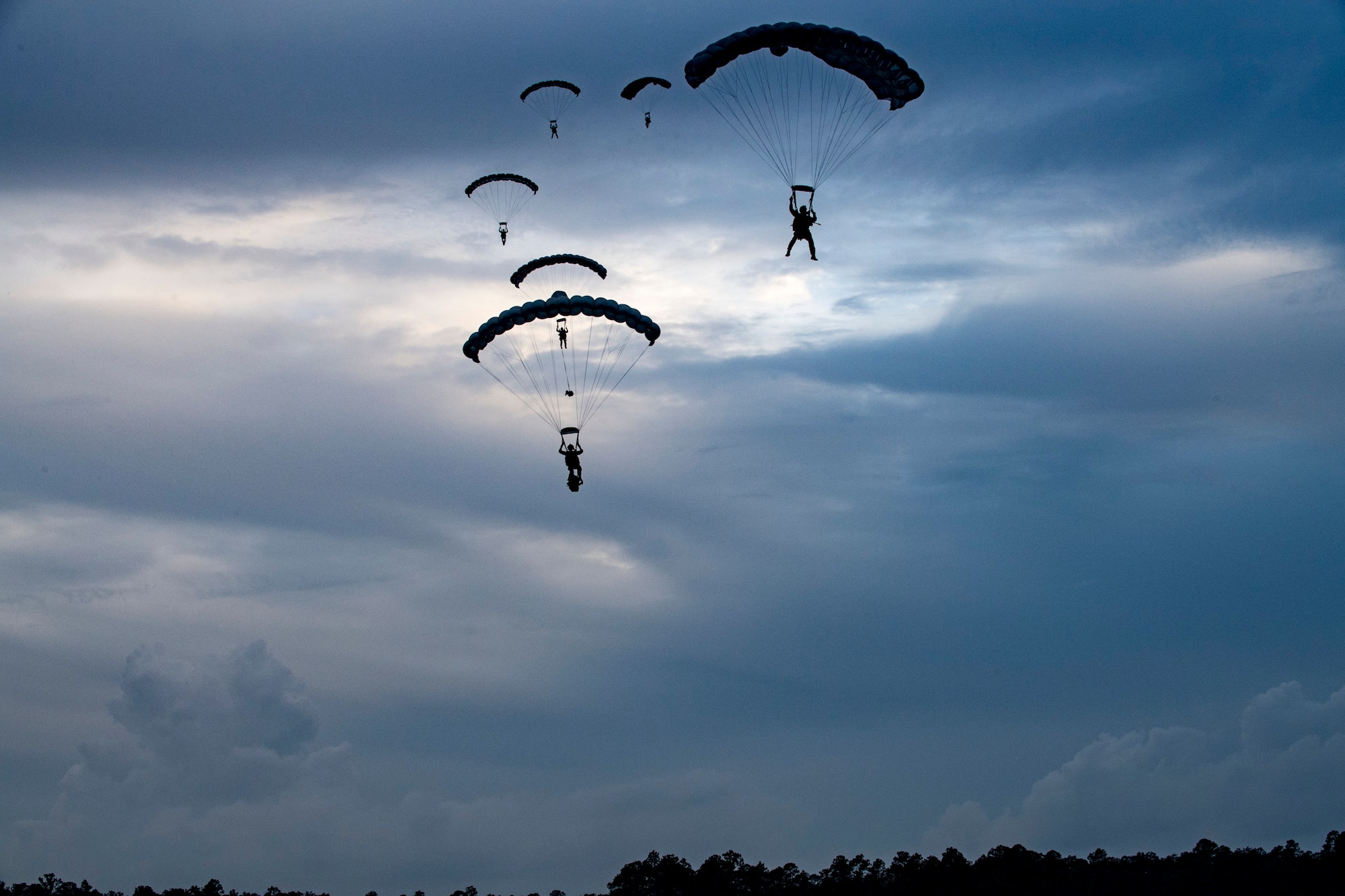 Pararescuemen from the 38th Rescue Squadron parachute towards the ground during a rescue exercise, June 21, 2017, at Bemiss Field landing zone, Ga. The Air Force Research Laboratory from Wright-Patterson Air Force Base, Ohio and the Baltimore U.S. Air Force Center for Sustainment of Trauma and Readiness Skills, observed Moody's Combat Search and Rescue aeromedical patient processes and survival kit technology, in hopes of reducing risks to improve the overall Air Force mission. (U.S. Air Force photo by Airman 1st Class Daniel Snider)