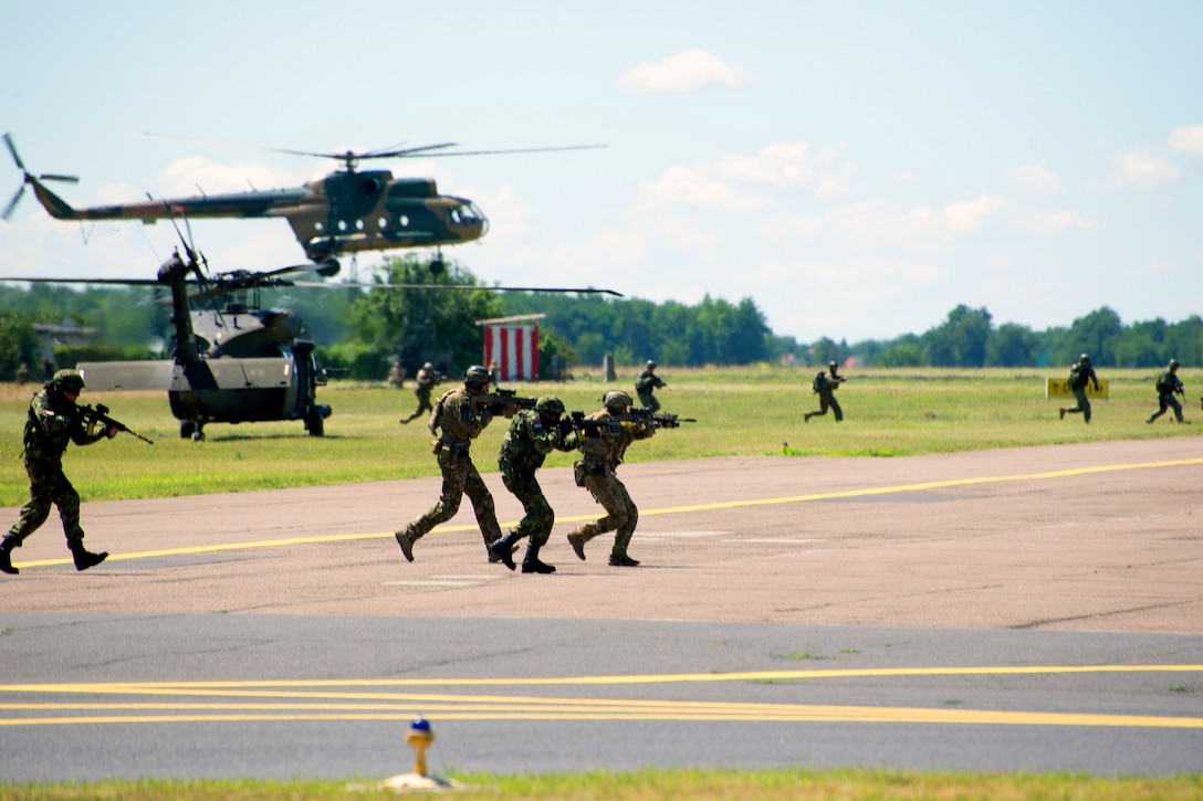 American, Hungarian, Romanian, Slovenian and Croatian special operations forces assault a building from U.S. UH-60 Black Hawk helicopters assigned to the 10th Combat Aviation Brigade, while Hungarian special operations forces fast rope from a Hungarian Mi-8 Multirole Medium-Lift helicopter during exercise Black Swan in Szolnok, Hungary, July 21, 2017. Army photo by Staff Sgt. Aaron Duncan