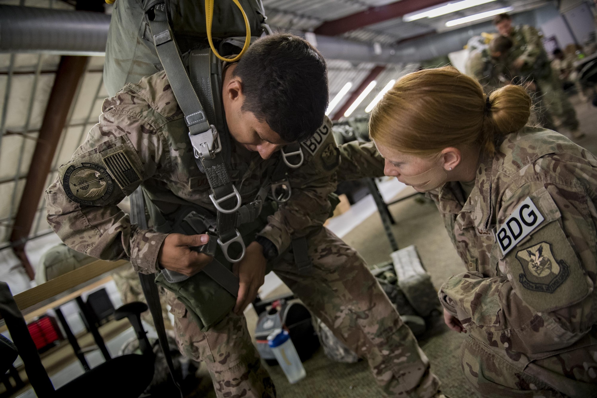 Staff Sgt. Luis Dominguez and Senior Airman Jenny Walker, 823d Base Defense Squadron close precision engagement team members, ensure Dominguez’s gear is equipped properly, July 21, 2017, at Moody Air Force Base, Ga. This training was in preparation for an upcoming mission readiness exercise where airmen serve as an airborne advanced team, with the mission to create an initial presence and clear a path for follow-on forces to arrive on scene. (U.S. Air Force photo by Airman 1st Class Daniel Snider)