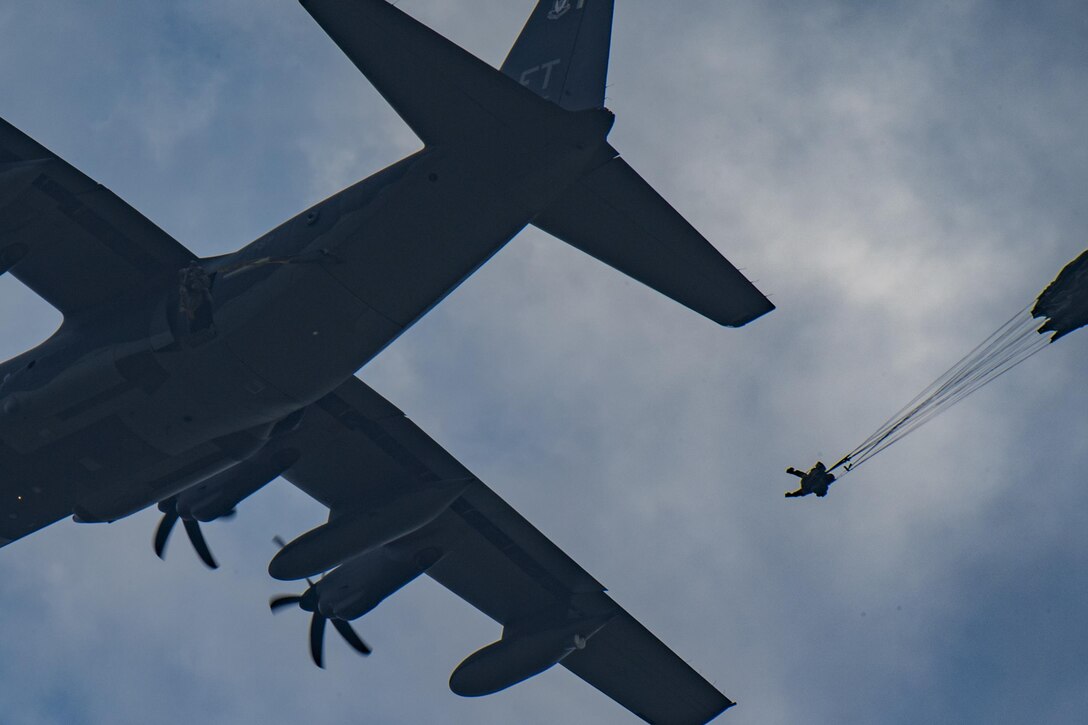 A member of the 823d Base Defense Squadron drops from an HC-130J Combat King II as his parachute catches wind, July 21, 2017, at the Lee Fulp Drop Zone in Tifton, Ga. This training was in preparation for an upcoming mission readiness exercise where airmen serve as an airborne advanced team, with the mission to create an initial presence and clear a path for follow-on forces to arrive on scene. (U.S. Air Force photo by Airman 1st Class Daniel Snider)