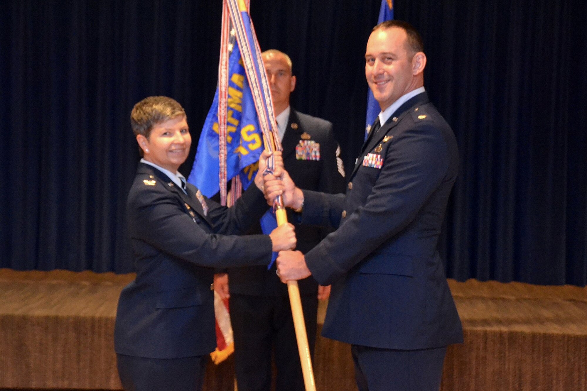 PETERSON AIR FORCE BASE, Colo. —Col. Heidi A. Paulson, Air Force Manpower Analysis Agency commander, hands the guidon for the 4th Manpower Requirements Squadron to Lt. Col. Ryan F. Caulk, June 27, 2017, at Peterson Air Force Base, Colo. Paulson presided over the ceremony at the base auditorium. (Courtesy photo)