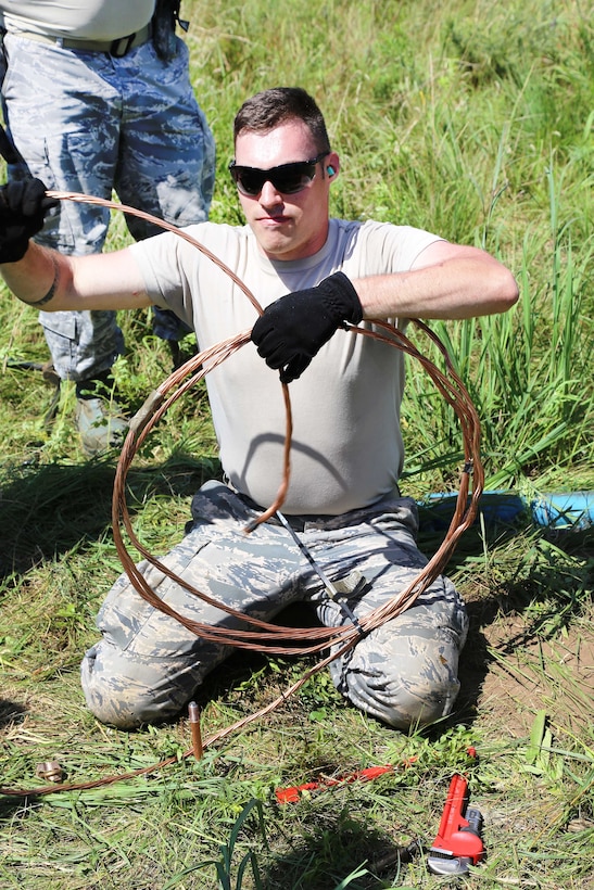 An Oregon Air National Guardsman connects cable and equipment for a mobile tower and a tactical air navigation system to allow for air traffic control operations during the Patriot North 2017 exercise at the Young Air Assault landing strip at Fort McCoy, Wis., July 17, 2017. Army photo by Scott T. Sturkol