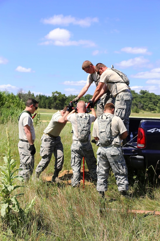 Oregon Air National Guardsmen use a gas auger to drill a hole before setting up equipment for a mobile tower and a tactical air navigation system to allow for air traffic control operations during the Patriot North 2017 exercise at the Young Air Assault landing strip at Fort McCoy, Wis., July 17, 2017. Army photo by Scott T. Sturkol