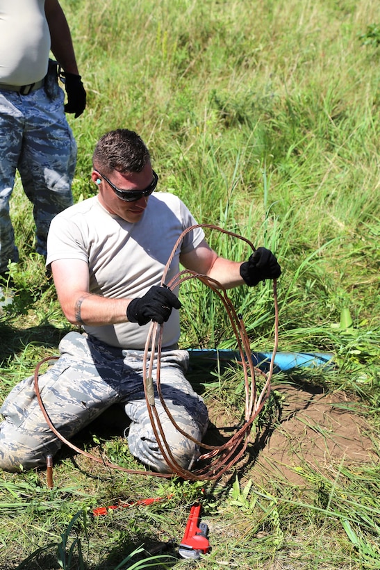 An Oregon Air National Guardsman unwinds a cable before connecting it to equipment for a mobile tower and a tactical air navigation system to allow for air traffic control operations during the Patriot North 2017 exercise at the Young Air Assault landing strip at Fort McCoy, Wis., July 17, 2017. Army photo by Scott T. Sturkol
