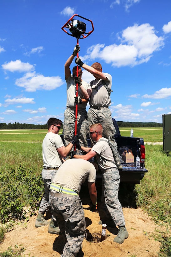 Oregon Air National Guardsmen prepare to use a gas auger to drill a hole before setting up equipment for a mobile tower and a tactical air navigation system to allow for air traffic control operations during the Patriot North 2017 exercise at the Young Air Assault landing strip at Fort McCoy, Wis., July 17, 2017. Army photo by Scott T. Sturkol