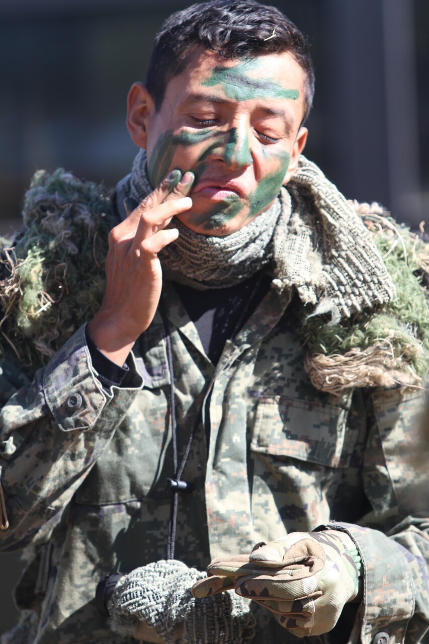 A Mexican competitor covers his face with green paint in preparation of the stalk-and-shoot event during Fuerzas Comando in Ñu Guazú, Paraguay, July 20, 2017. U.S. Army photo by Spc. Tonya Deardorf