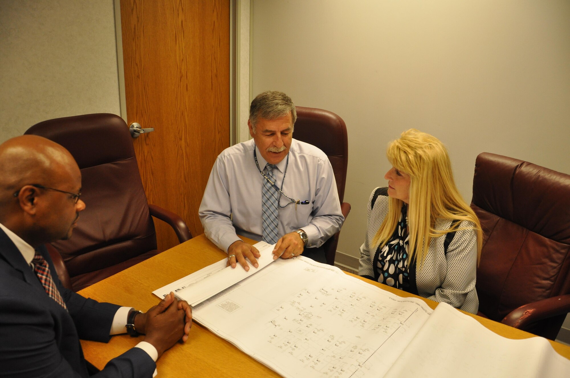 Dr. Mike Hassan (middle), chief of the Air Force Security Assistance and Cooperation Directorate’s Construction Branch, confers with Dr. Carlos Braziel, section chief for Requirements and Small Programs and Diane DiTommaso, program manager,  on a construction project overseas. (U.S. Air Force photo/Brian Brackens)