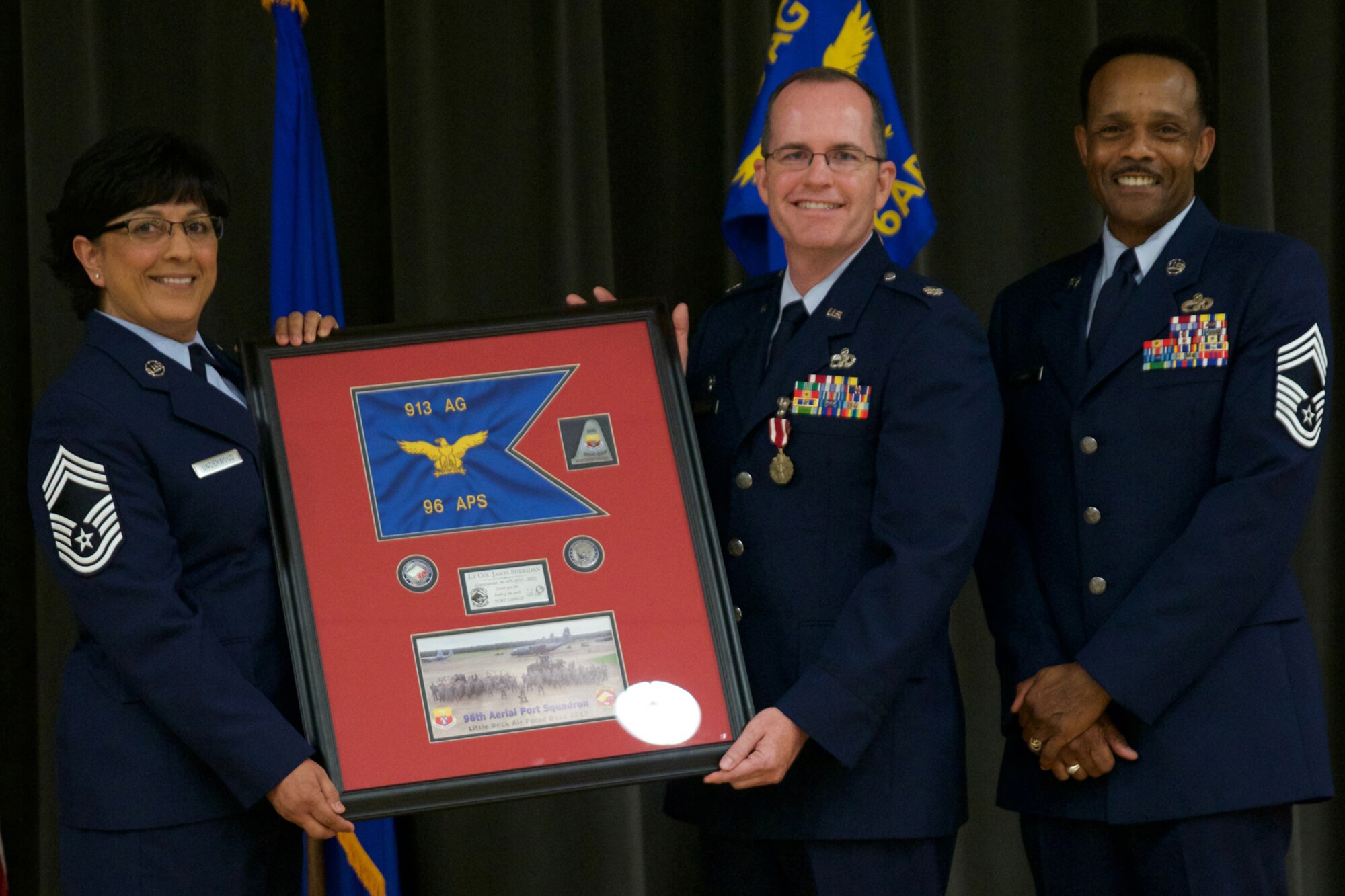 U.S. Air Force Reserve Chief Master Sgt. Cynthia Underwood, the air transportation superintendent for the 96th Aerial Port Squadron, Lt. Col. Jason Sheridan, and Chief Master Sgt. Alvin Glover, operations superintendent, 96 APS, pose for a photo during Sheridan’s retirement ceremony at Little Rock Air Force Base, Ark., July 8, 2017. Sheridan, a former 96 APS commander, retired after 22 years of service. (U.S. Air Force photo by Capt. Casey Staheli/Released)