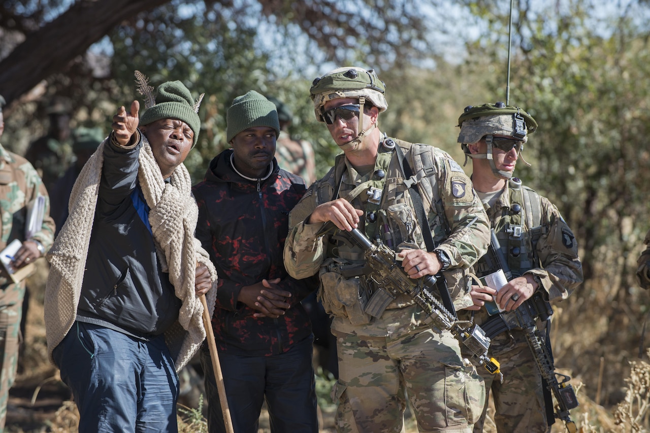 Army First Lt. Zach Lewis, right, a platoon leader with the 101st Airborne Division's 2nd Battalion, 327th Infantry Regiment, speaks with a village elder played by a South African soldier during situational training for Shared Accord 17 at the South African Army Combat Training Center in Lohatla, July 21, 2017. The elder told the soldiers that a family member had been kidnapped by insurgents and he needed their help. The two-week exercise, which ends Aug. 3, enhances the peacekeeping capabilities of U.S. and African forces. DoD photo by Sean Kimmons