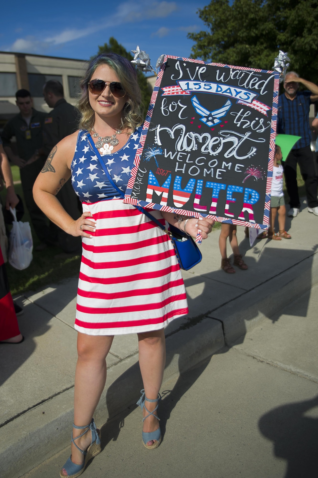 Danielle McCarthy strikes a patriotic pose as she awaits the return of Staff Sgt. Michael Multer, 714th Aircraft Maintenance Squadron, from his four month deployment. 514th Air Mobility Wing air crew and maintainers returned from their respective two-month and four-month deployments to Southwest Asia July 26. (U.S. Air Force photo by Christian DeLuca/released)