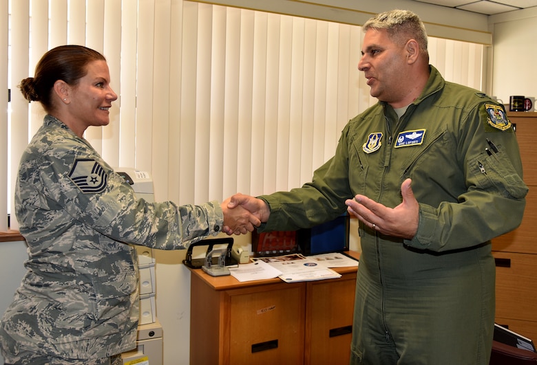 Col. Michael LoForti, 920th Operations Group commander, presents Master Sgt. Isabelle Klier-Graham, 920th Rescue Wing Equal Opportunity advisor, with his commander's coin July 9, 2017 to thank her for her assistance in the long-range rescue of two German citizens whose vessel caught fire approximately 500 nautical miles east of the Florida coastline in the Bermuda Triangle. Klier-Graham, a Bayreuth, Germany, native, worked as a German translator on the mission. (U.S. Air Force photo/Senior Airman Brandon Kalloo-Sanes)