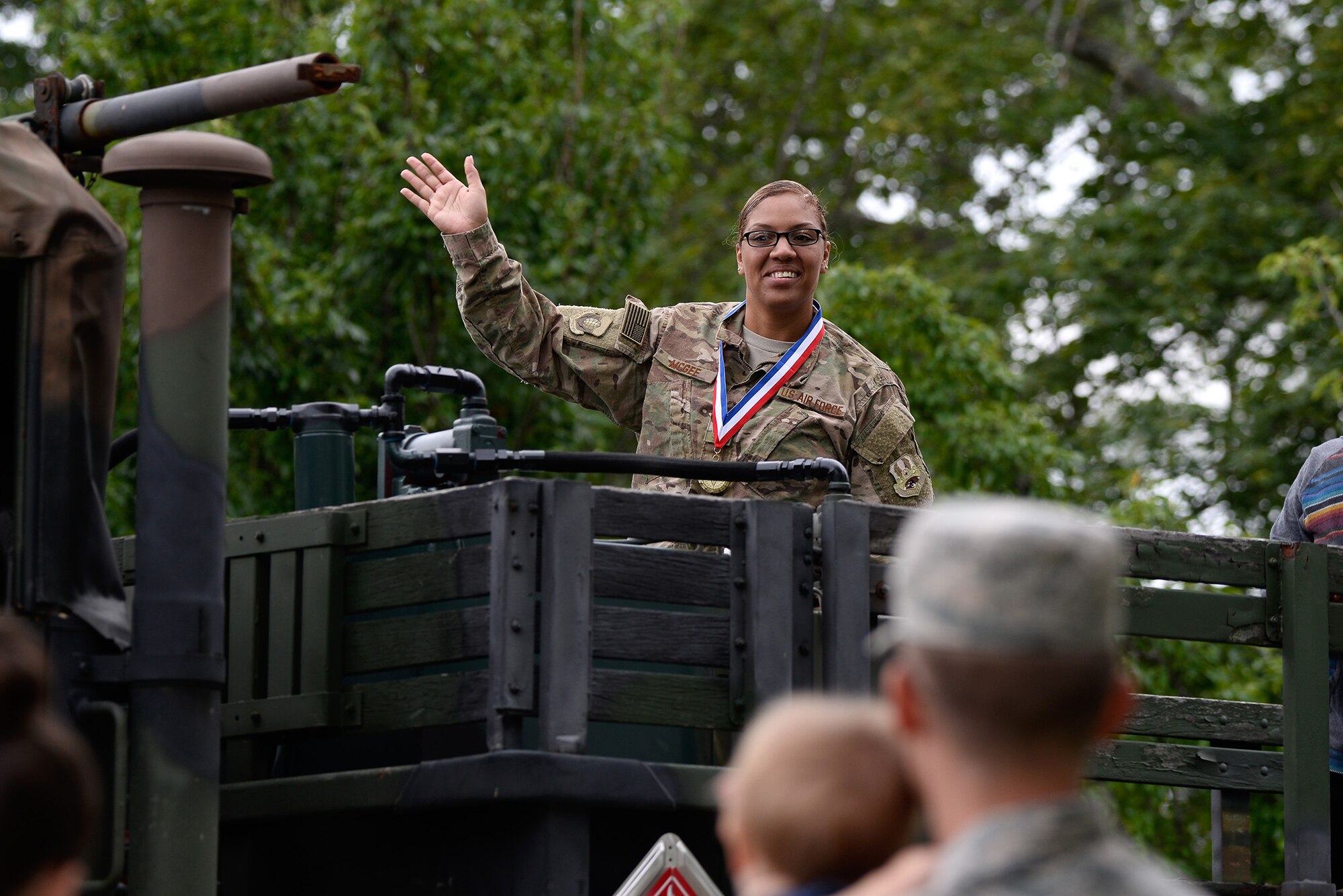 Master Sgt. Chrystle McGee a budget anayst with the 66th Comptroller Squadron, waves to the crowd during a parade at Hanscom Air Force Base, Mass., July 27. The parade followed the Hanscom Heroes Homecoming event at the base conference center that recognized Airmen who have returned home from deployment in the past year. (U.S Air Force photo by Mark Herlihy)