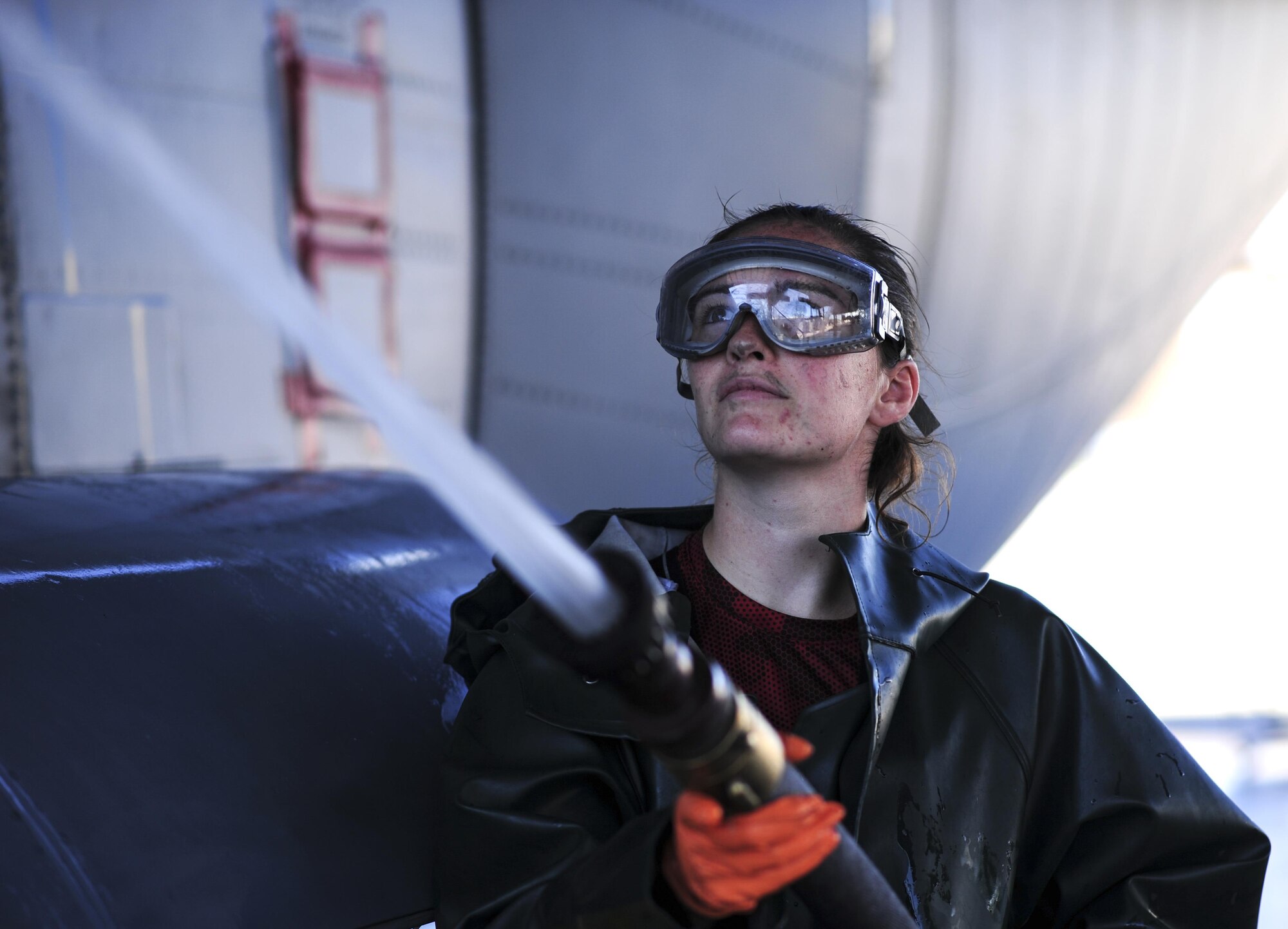 U.S. Air Force Airman 1st Class Meaghan Woods, 755th Aircraft Maintenance Squadron EC-130H Compass Call crew chief, power washes the side of an EC-130H at Davis-Monthan Air Force Base, Ariz., July 25, 2017. Airmen use pressure washers with an output of more than 3,000 pounds of pressure per square inch to clean the aircraft. (U.S. Air Force photo by Airman 1st Class Michael X. Beyer)