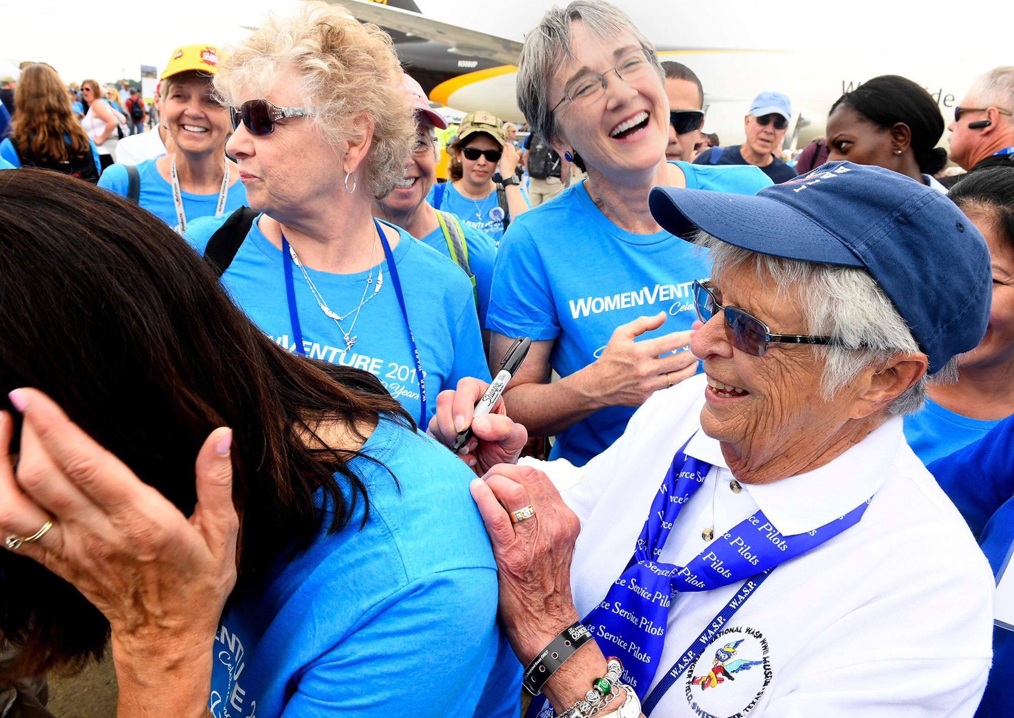 Secretary of the Air Force Heather Wilson laughs with Women's Auxiliary Service Pilot Jane Doyle while she autographs a T-shirt following a group portrait of women aviators in Oshkosh, Wisc., July 26, 2017. (U.S. Air Force photo/Scott M. Ash)