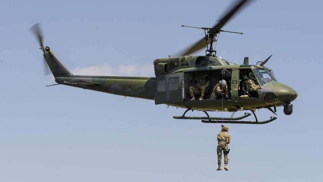 Airmen hoist Staff Sgt. Pedro Mangual-Rivera up to a UH-1N Iroquois helicopter during rescue hoist training at Camp Gilbert C. Grafton near Devils Lake, N.D., July 20, 2017. Mangual-Rivera is assigned to the 219th Security Forces Squadron, North Dakota Air National Guard.  Air National Guard photo by Senior Master Sgt. David H. Lipp