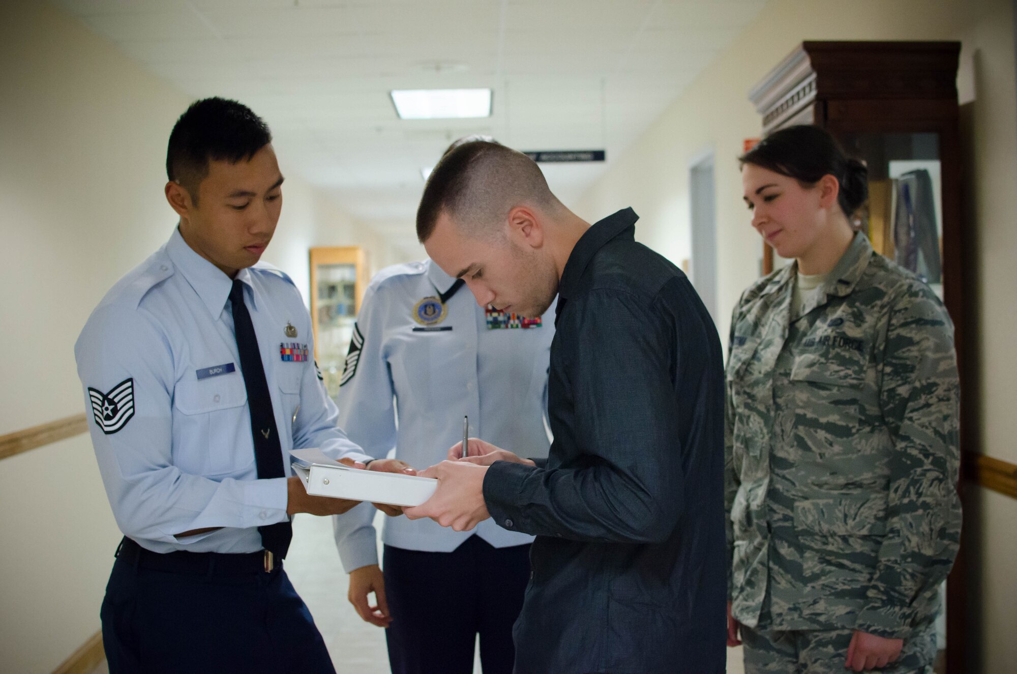 Tech. Sgt. Badin Burch, 403rd Wing recruiter, helps Senior Airman Brian Heiney, 403rd Security Forces Squadron fire team member, fill out enlistment paperwork November 13, 2016 at Keesler Air Force Base, Mississippi. (U.S. Air Force photo/Staff Sgt. Heather Heiney)