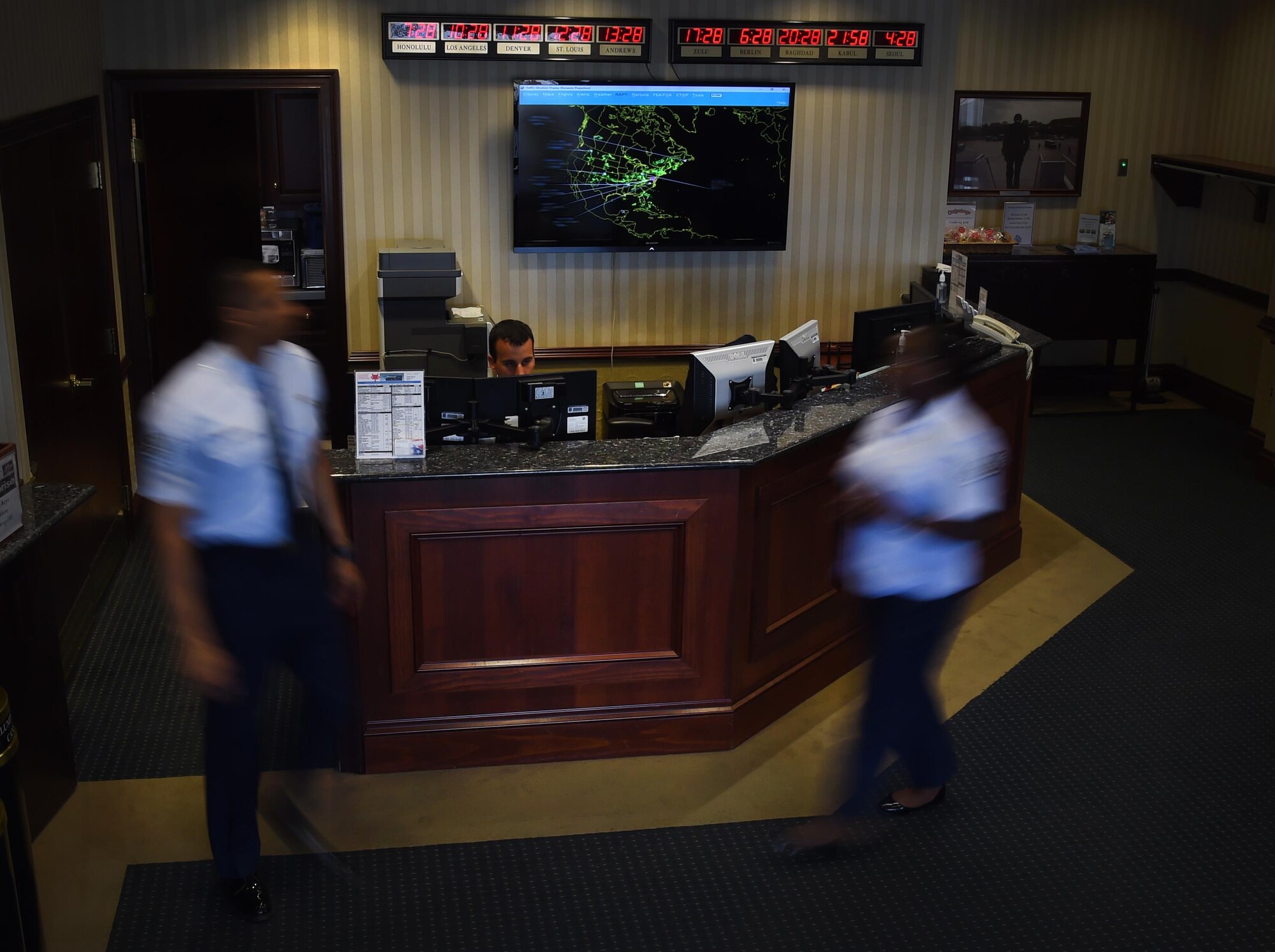 Airmen of the 89th Airlift Wing flight line protocol office walk busily around the Distinguished Visitor’s Lounge on Joint Base Andrews, Md., July 27, 2017. These Airmen directly support the president, vice president, first lady, Secretary of Defense, Secretary of State, Chairman of the Joint Chiefs of Staff, and foreign dignitaries. (U.S. Air Force photo illustration by Senior Airman Mariah Haddenham)