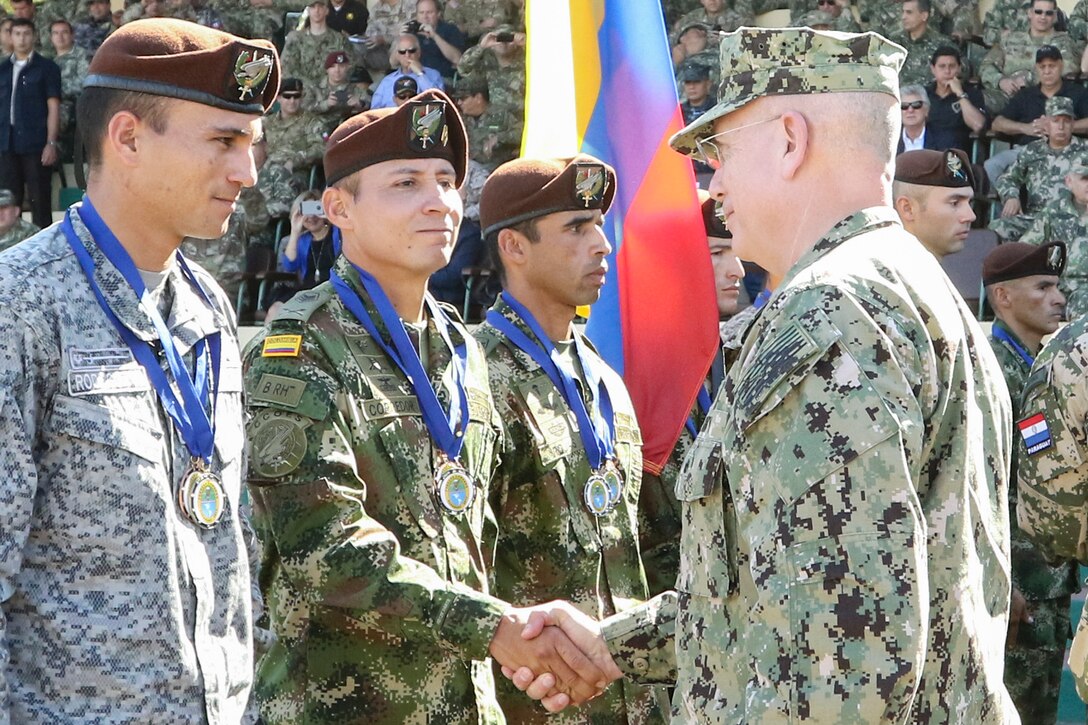 Navy Adm. Kurt W. Tidd, the commander of U.S. Southern Command, congratulates Colombian competitors during the closing ceremony of Fuerzas Comando in Mariano Roque Alonso, Paraguay, July 27, 2017. Army photo by Sgt. Joanna Bradshaw