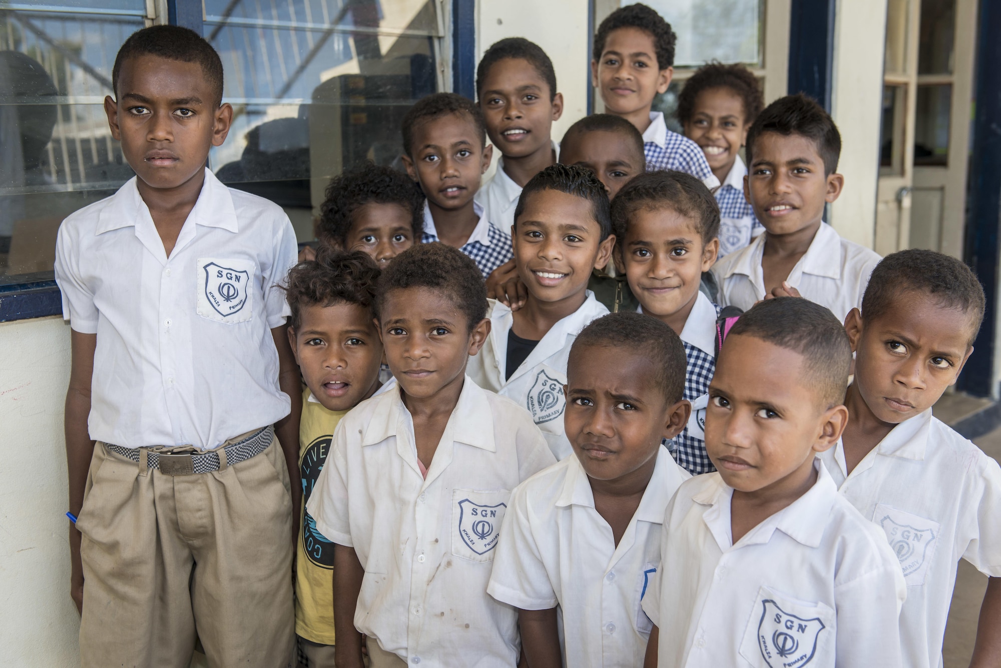 A group of Fijian students pose for the camera at Khalsa Primary School during Pacific Angel (PACANGEL) 17-3 in Ba, Fiji, July 18, 2017. The kids were joined by several U.S. and Fijian engineers working together to install new and renovate existing infrastructure such as ceiling fans and water piping. PACANGEL builds partnerships between the US, Fiji, and several regional nations by conducting multilateral humanitarian assistance and civil military operations, promoting regional military-civilian-nongovernmental organization cooperation and interoperability. (U.S. Air Force photo/Tech. Sgt. Benjamin W. Stratton)
