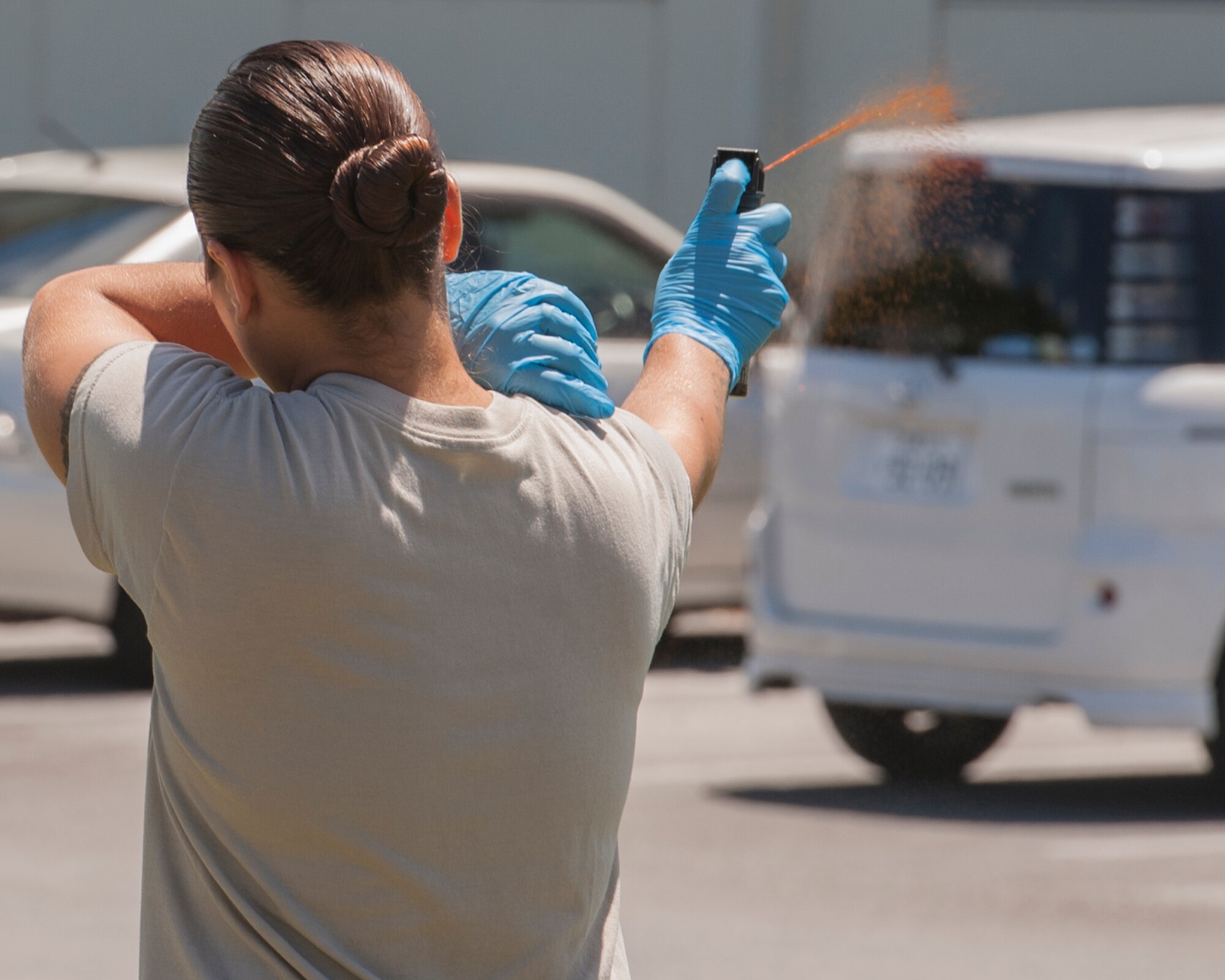 U.S. Air Force Staff Sgt. Felicity Walker, 18th Security Forces Squadron trainer, test sprays the OC spray for demonstration during Taser and oleoresin capsicum (OC)  spray training July 20, 2017, at Kadena Air Base, Japan. The OC spray is similar to pepper spray, and induces a burning sensation to the affected region of the body. (U.S. Air Force photo/ Airman 1st Class Greg Erwin)