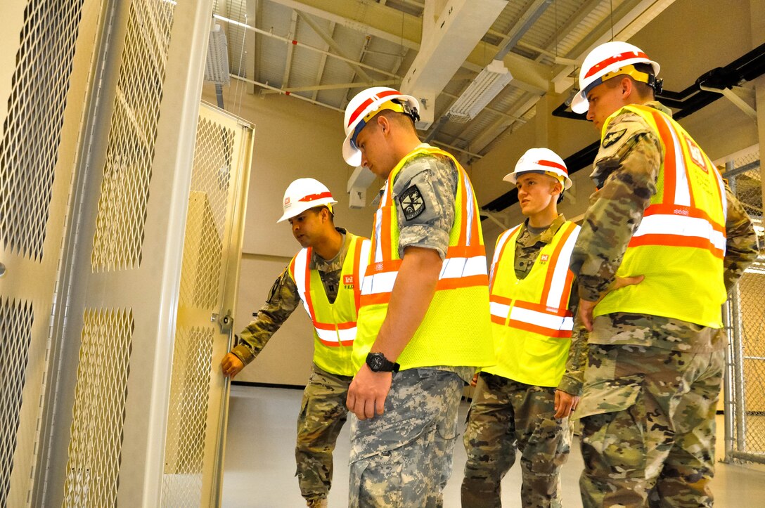 Capt. Rodolfo Martinez (far left) a project engineer, inspects a wall locker and explains deficiencies to Cadet Drako Gagnon (left) University of Winsconsin-River Falls, Cadet Tim Gephart (center)  United States Military Academy, and Cadet Caleb Kowalski University of Winsconsin-Madison, during a site walk on July 27, 2017.