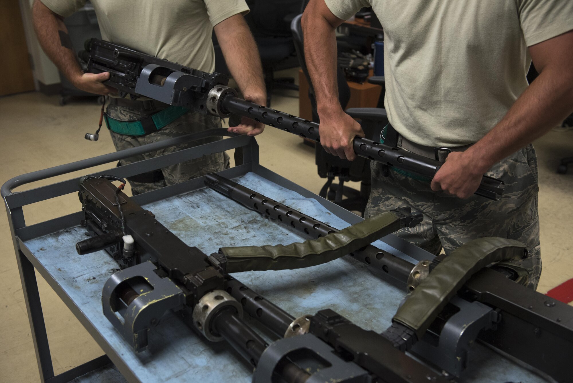 A U.S. Air Force Airman from the 33rd Helicopter Maintenance Unit places a GAU-18 50-caliber machine gun on a cart July 26, 2017, at Kadena Air Base, Japan. Armament Airmen work on the flightline and in the back-shop 24/7 in order to provide combat, counter-air capabilities to every HH-60 Pave Hawk in the 33rd Rescue Squadron. (U.S. Air Force photo by Senior Airman John Linzmeier)