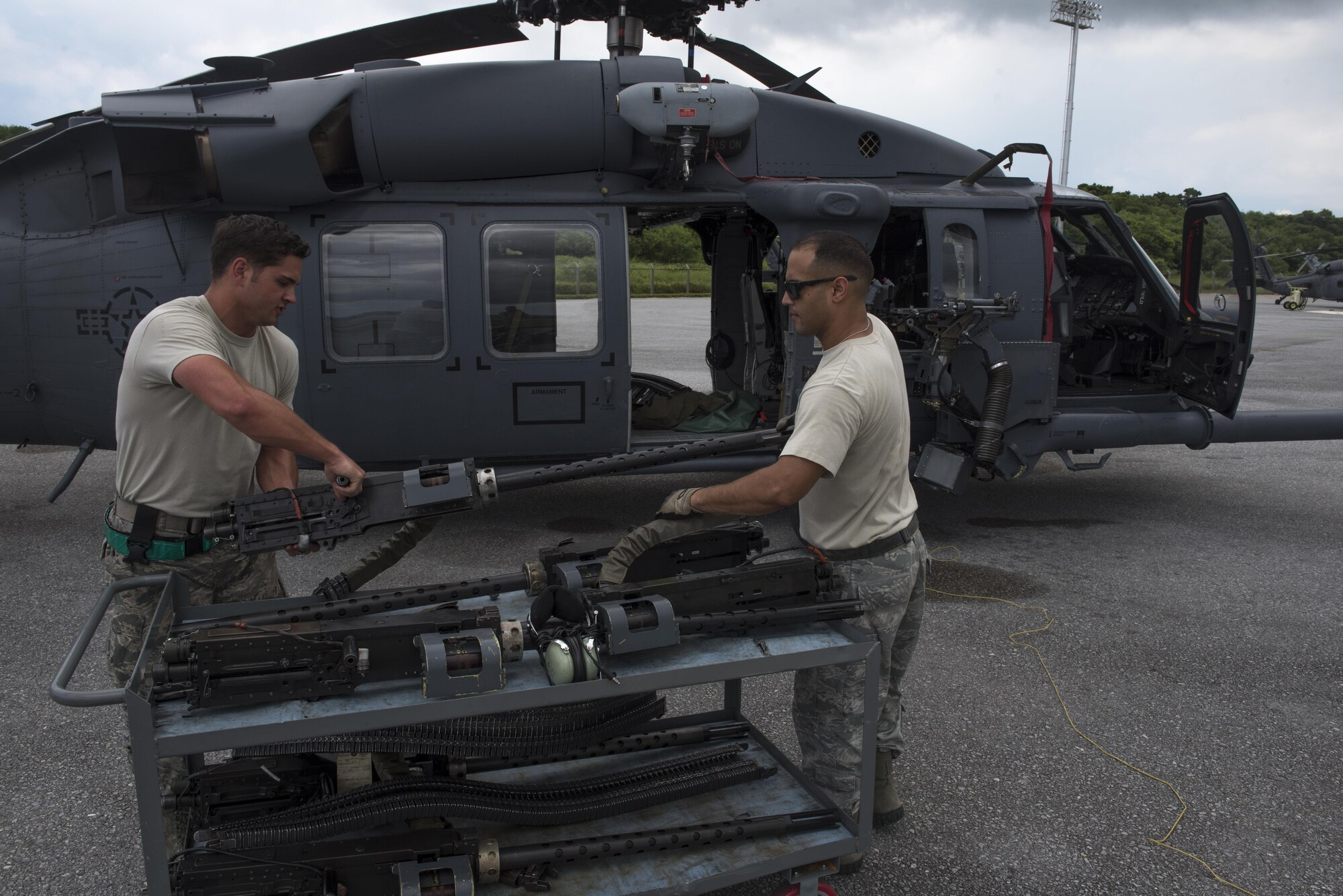U.S. Air Force Staff Sgt. Ryan Anderson and Tech. Sgt. Josean Arce, 33rd Helicopter Maintenance Unit weapons section weapons technicians, ready a GAU-18 50-caliber machine gun to be loaded onto an HH-60 Pave Hawk from the 33rd Rescue Squadron July 26, 2017, at Kadena Air Base, Japan. When mounted to an HH-60 Pave Hawk, the weapons are manned by special mission aviators for real-world and training operations. (U.S. Air Force photo by Senior Airman John Linzmeier)