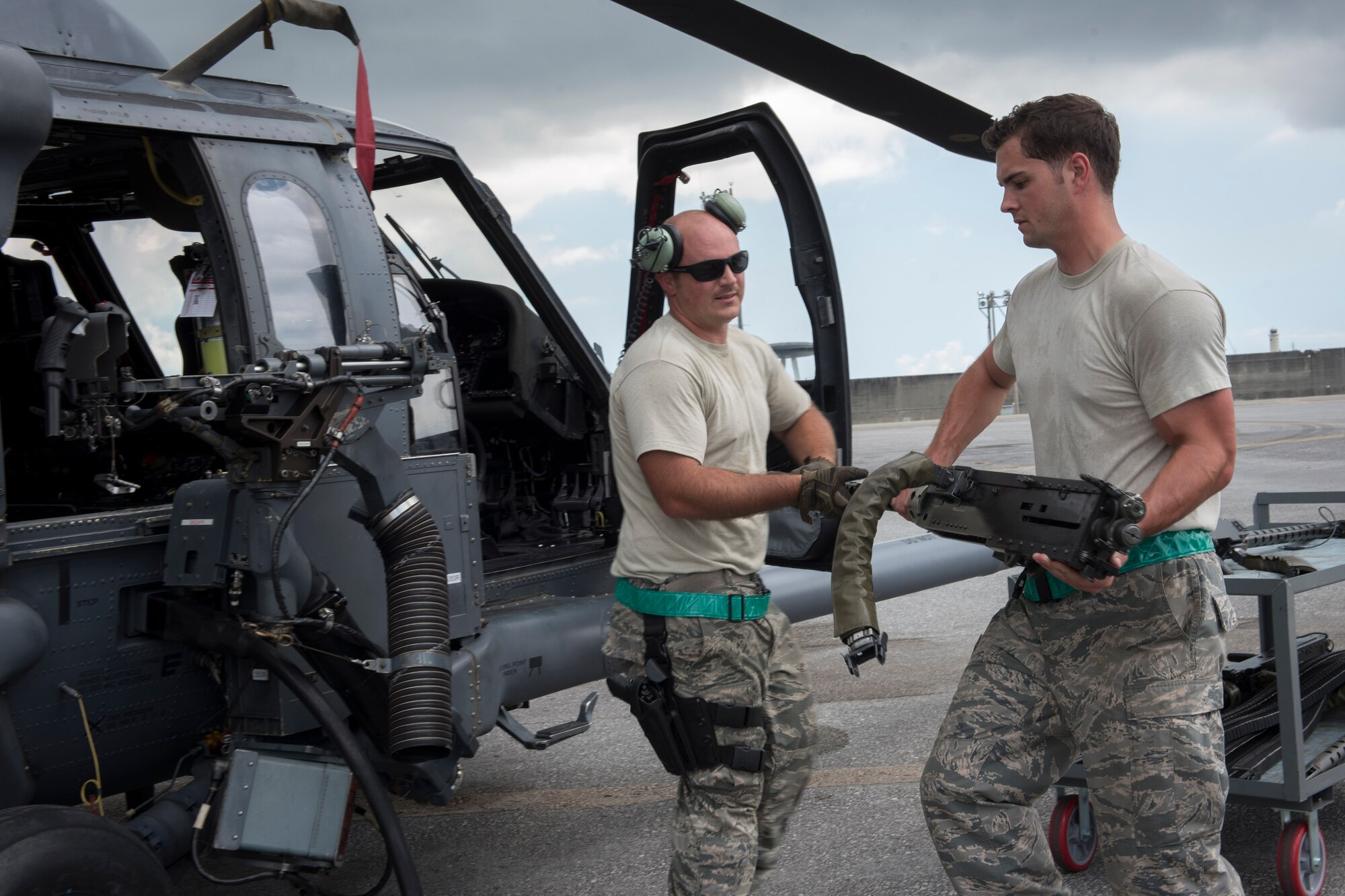 U.S. Air Force Senior Airman Zachary Hough and Staff Sgt. Ryan Anderson, 33rd Helicopter Maintenance Unit weapons section weapons load technicians, load a GAU-18 50-caliber machine gun onto an HH-60 Pave Hawk from the 33rd Rescue Squadron July 26, 2017, at Kadena Air Base, Japan. The 33rd RQS plays a vital part in maintaining peace and stability in the Pacific Region by providing forward power projection as well as search, rescue and recovery mission capabilities. (U.S. Air Force photo by Senior Airman John Linzmeier)