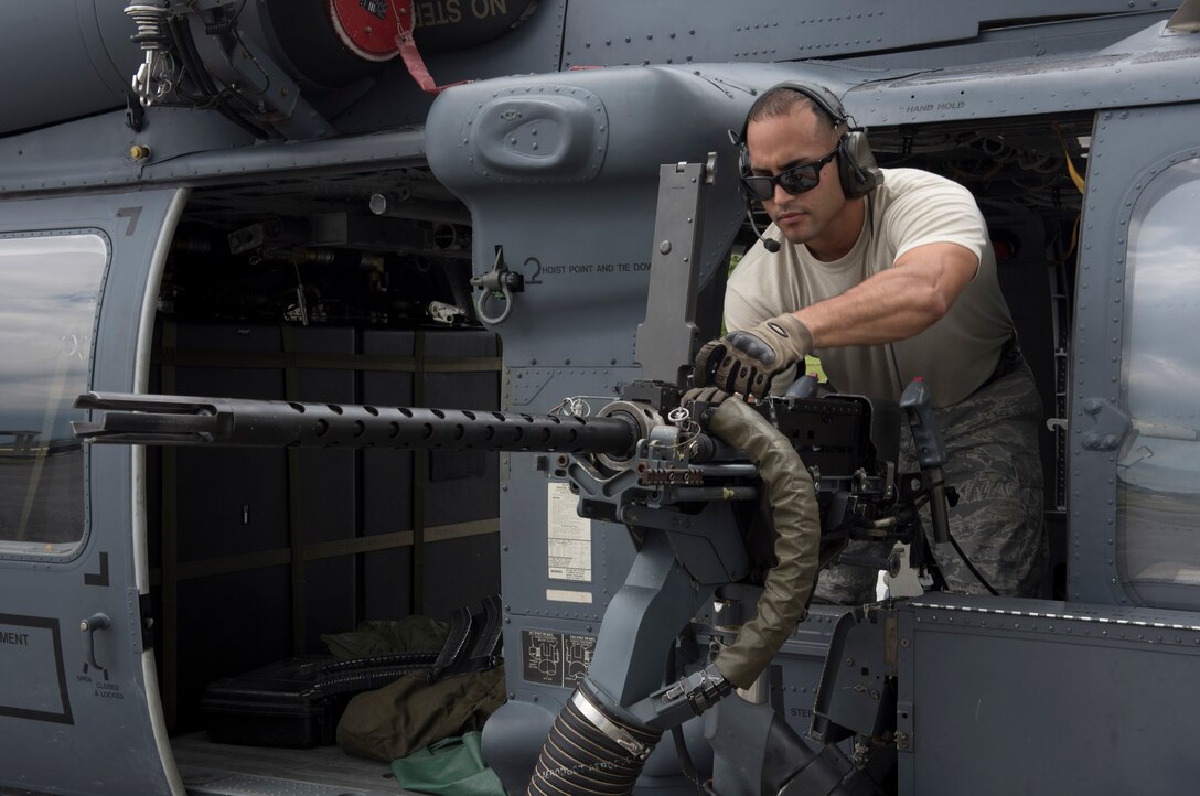 U.S. Air Force Tech. Sgt. Josean Arce, 33rd Helicopter Maintenance Unit weapons section weapons expediter, performs a systems check on a GAU-18 50-caliber machine gun mounted to an HH-60 Pave Hawk from the 33rd Rescue Squadron July 26, 2017, at Kadena Air Base, Japan. Airmen in the weapons section maintain, install, remove and safeguard all armaments and items associated with the HH-60 gun mounting and ammunition handling systems for the 33rd Rescue Squadron. (U.S. Air Force photo by Senior Airman John Linzmeier)