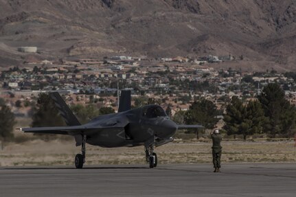 A pilot with Marine Fighter Attack Squadron (VMFA) 211 “Wake Island Avengers,” 3rd Marine Aircraft Wing, signals to a ground crew member after landing at Nellis Air Force Base, Nev., July 5. A total of 10 F-35B Lightning IIs and 250 Marines with VMFA-211 participated in Red Flag 17-3, a realistic combat training exercise hosted by the U.S. Air Force, to assess the squadron’s ability to deploy and support contingency operations using the F-35B. (U.S. Marine Corps photo by Sgt. Lillian Stephens/Released)