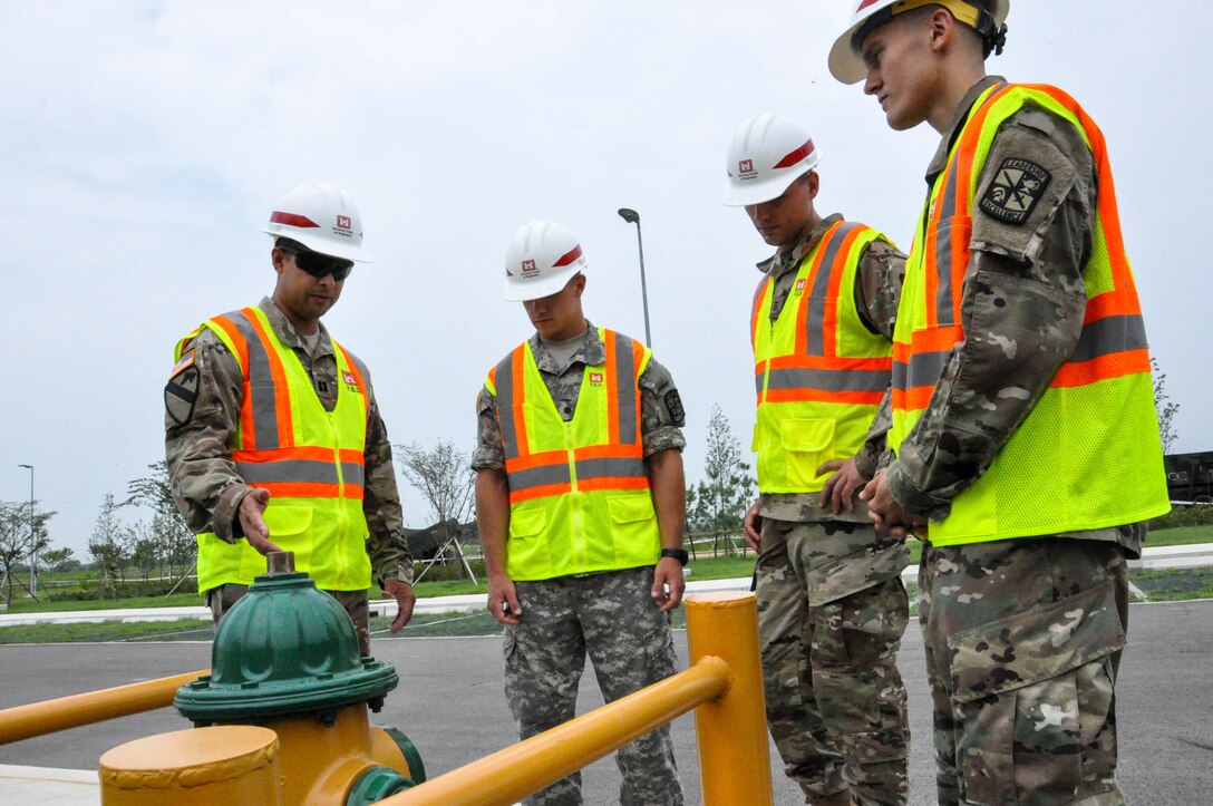 Capt. Rodolfo Martinez (left) a project engineer, explains a fire extinguisher modification to Cadet Caleb Kowalski (left), University of Winsconsin-Madison, Cadet Tim Gephart (center) United States Military Academy, and Cadet Drako Gagnon, University of Winsconsin-River Falls, during a site walk on July 27, 2017. 


