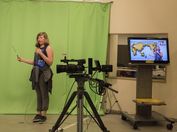 Olivia Forester, a Marine Corps Air Station Iwakuni resident, role-plays as a meteorologist during a trip with the Youth and Teen Center to Kidzania in Kobe, Japan, July 26, 2017. Kidzania is an indoor education entertainment center that provides children the interactive experience of working adult jobs and earning currency. Children are able to dress up and role-play as adults in nearly 100 jobs and activities with each profession offering the chance to use life-like tools and equipment. (U.S. Marine Corps photo by Lance Cpl. Carlos Jimenez)