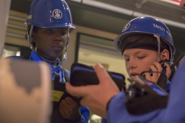 Ciera Roberts, left, and Carter Staley, Marine Corps Air Station Iwakuni residents, dress up as waterworks service workers during a trip with the Youth and Teen Center to Kidzania in Kobe, Japan, July 26, 2017. Kidzania is an indoor education entertainment center that provides children the interactive experience of working adult jobs and earning currency. Children are able to dress up and role-play as adults in nearly 100 jobs and activities with each profession offering the chance to use life-like tools and equipment. (U.S. Marine Corps photo by Lance Cpl. Carlos Jimenez)