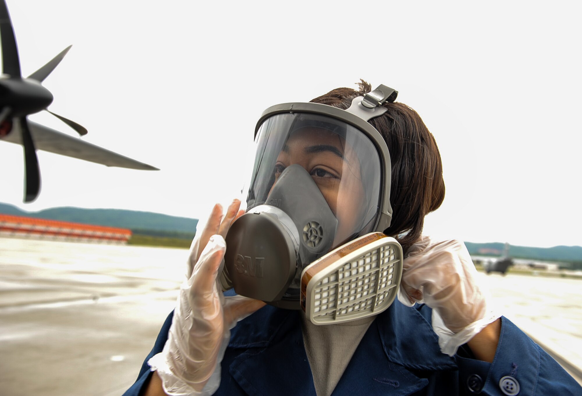 Airman 1st Class Arielle Howze, 786th Civil Engineer Squadron pest management journeyman, tightens her respirator before spraying aircraft insecticide on Ramstein Air Base, Germany, July 27, 2017. The aircraft insecticide helps prevent the spread of insects and the bacteria or viruses they carry, which can cause disease in humans, plants, and animals. (U.S. Air Force Airman 1st Class Savannah L. Waters)