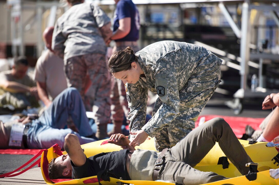 An Idaho Army National Guardsman provides medical care to a mock casualty during a major accident response exercise at Gowen Field in Boise, Idaho, July 21, 2017. Air National Guard photo by Tech. Sgt. John Winn