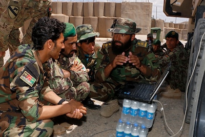 An Afghan National Army officer teaches ANA Soldiers about filling Electronic Warfare equipment under supervision of Staff Sgt. Justin Hood, Electronic Warfare Specialist for the Military Advisor Team of Task Force Southeast, during an Electronic Warfare training July 6 with Afghan National Army Soldiers of the 203rd Thunder Corps on AP Lightning. The purpose of the Train, Advise and Assist mission is to enable and develop the Afghan National Defense Security Forces with systems and processes that will continue to enable them into the future. (U.S. Army photo provided by Sgt. Christopher B. Dennis, 1st Cavalry Division PAO.)