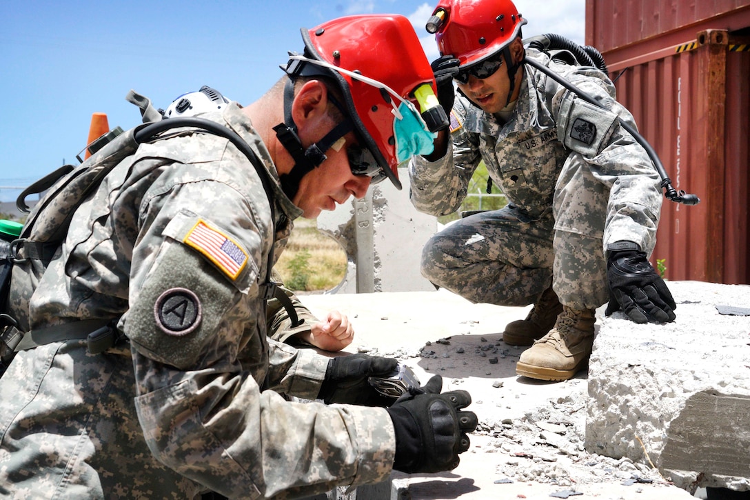 Hawaii Army National Guardsmen calculate the weight of a piece of debris before moving it to gain access to a mock casualty during a combined training exercise in Kalaeloa, Hawaii, July 18, 2017. Air National Guard photo by Tech. Sgt. Andrew Jackson