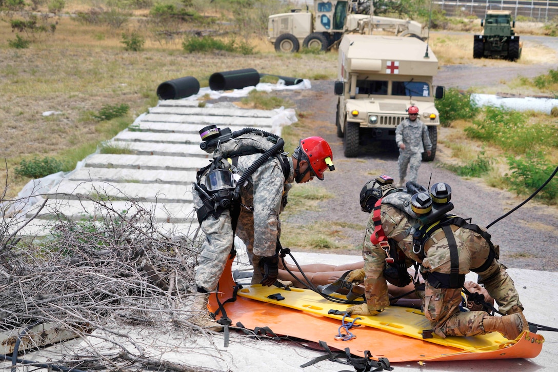 Hawaii Army National Guardsmen prepare to transport a mock casualty during a combined training exercise in Kalaeloa, Hawaii, July 18, 2017. Air National Guard photo by Tech. Sgt. Andrew Jackson