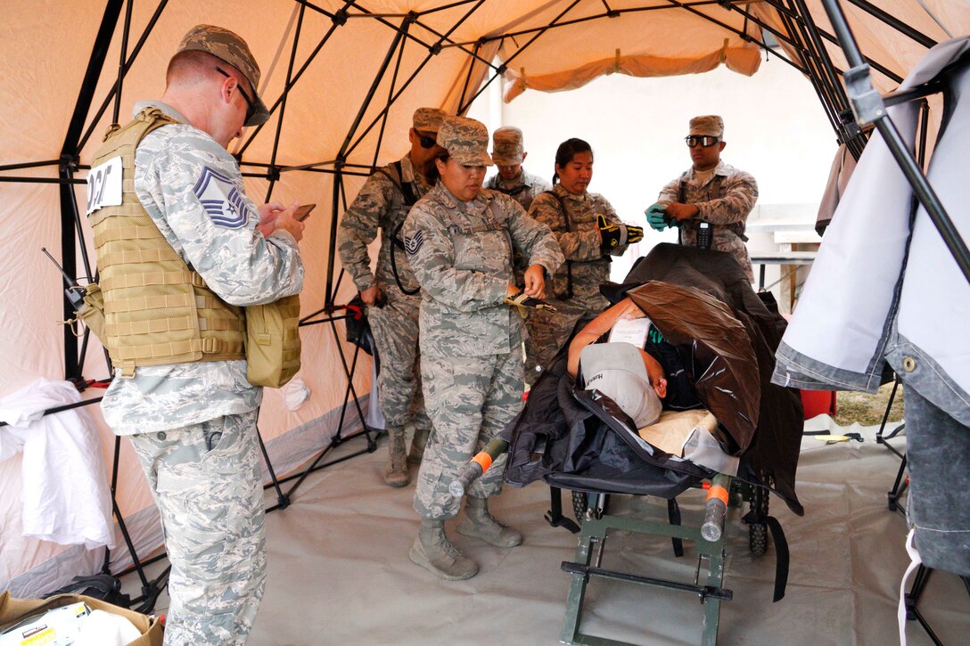 Hawaii Army National Guardsmen provide medical aid to a mock casualty during a combined training exercise in Kalaeloa, Hawaii, July 19, 2017. Air National Guard photo by Tech. Sgt. Andrew Jackson