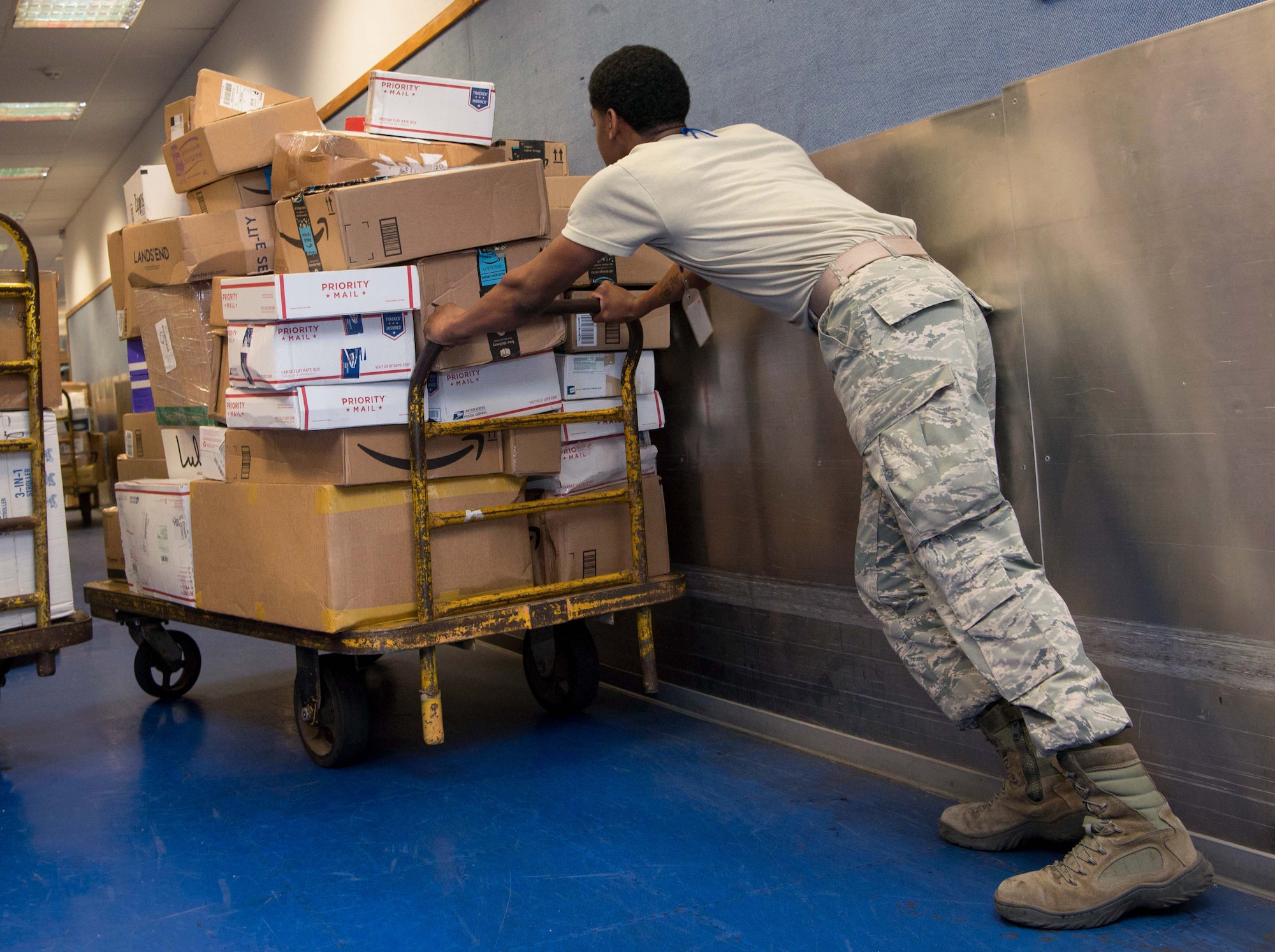 U.S. Air Force Airman 1st Class Aaron Oden, 86th Mission Support Group Communications Squadron North Side Post Office postal specialist pushes a cart of parcels at Ramstein Air Base, Germany, July 27, 2017. The North Side Post Office has cut delivery time by seven to ten days for those ordering from the Army and Air Force Exchange Service online in U.S. Air Forces Europe by delivering AAFES products from Ramstein rather than from the U.S. (U.S. Air Force photo by Senior Airman Elizabeth Baker)