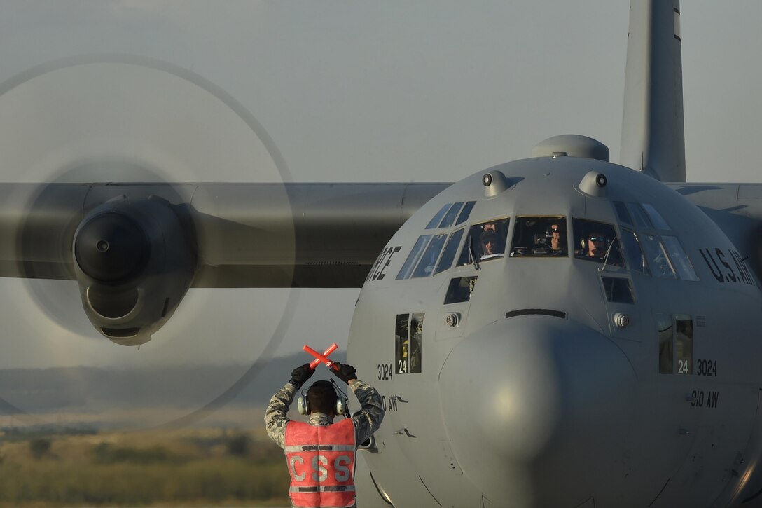 Staff Sgt. Nestor Fraga, a 321st Contingency Response Squadron aircraft maintainer, marshals a C-130 Hercules aircraft during Exercise Saber Guardian 17 at Bezmer Air Base, Bulgaria, July 19, 2017. The largest of the Black Sea region exercises, SG17 highlights participant deterrence capabilities, specifically the ability to mass forces at any given time anywhere in Europe to support the security and stability of the Black Sea region. (U.S. Air Force Photo/Tech. Sgt. Liliana Moreno)