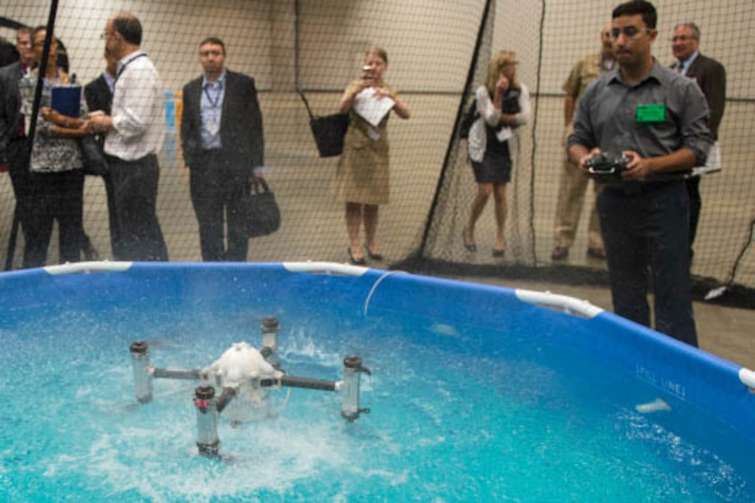 Marco Maia from Rutgers University operates Naviator, the first unmanned hybrid aerial-aquatic vehicle to seamlessly transition from airborne to underwater operations and back again, during the Naval Future Force Science and Technology Expo in Washington D.C.  Navy photo by John F. Williams